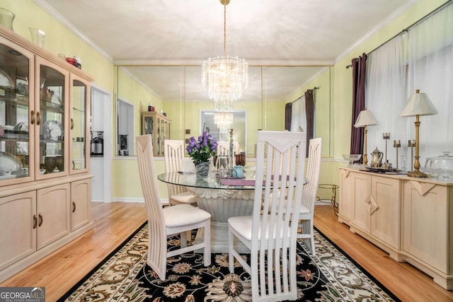 dining space featuring an inviting chandelier, ornamental molding, and light wood-type flooring