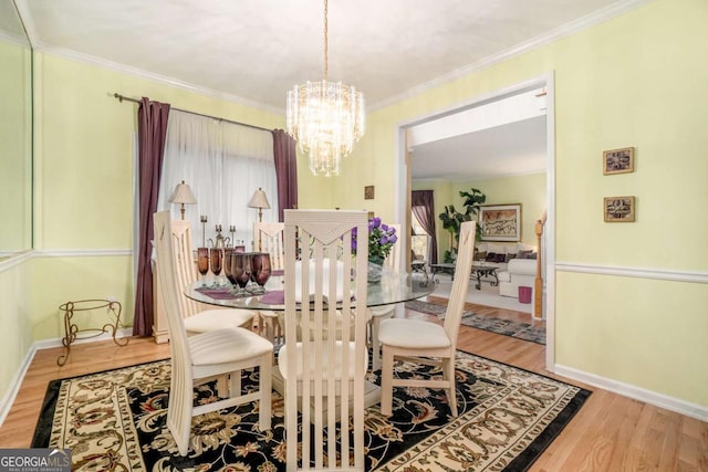 dining space featuring crown molding, hardwood / wood-style floors, and a chandelier