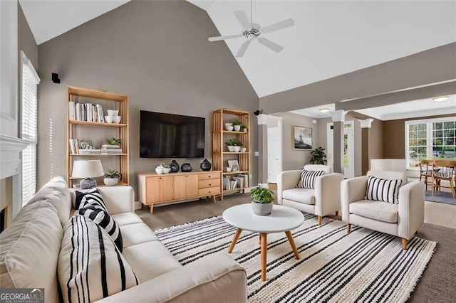 carpeted living room featuring decorative columns, high vaulted ceiling, and ceiling fan