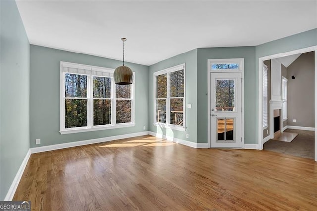 unfurnished dining area with hardwood / wood-style flooring and a healthy amount of sunlight