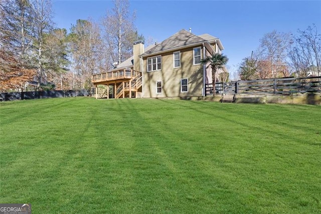 back of property featuring a lawn and a wooden deck