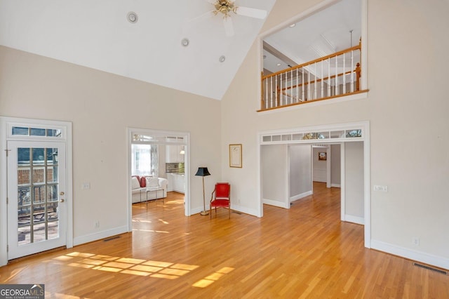 unfurnished living room featuring ceiling fan, high vaulted ceiling, and hardwood / wood-style flooring