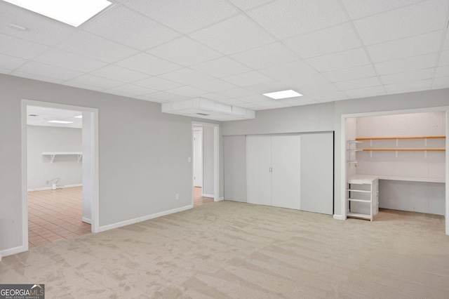 interior space featuring a paneled ceiling and light colored carpet