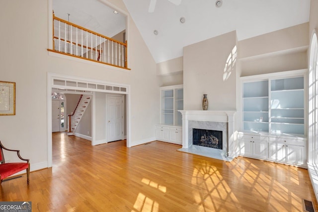 unfurnished living room with a fireplace, hardwood / wood-style flooring, and high vaulted ceiling