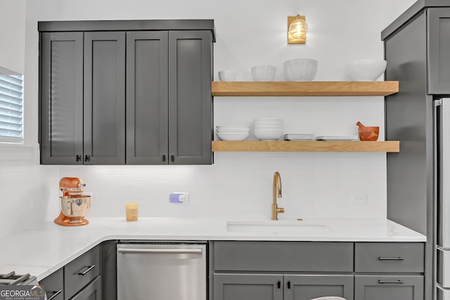 kitchen featuring gray cabinetry, dishwasher, and sink