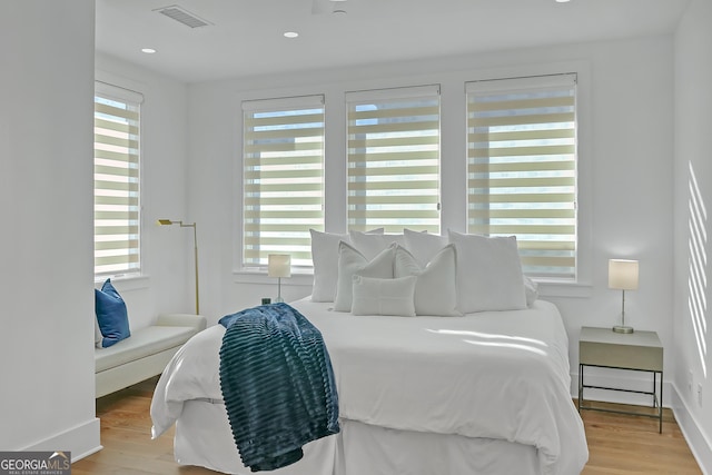 bedroom featuring light hardwood / wood-style floors and multiple windows