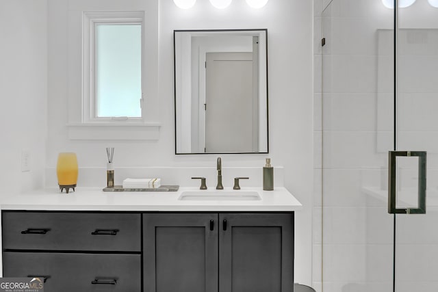 bathroom featuring a shower with door and vanity