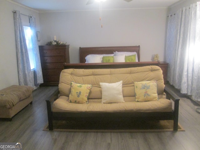 bedroom with crown molding, ceiling fan, and dark wood-type flooring