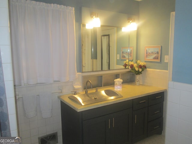 bathroom featuring sink and tile walls