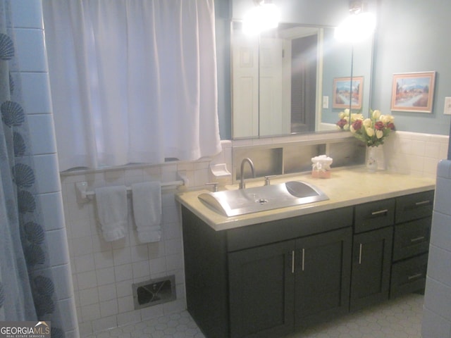 bathroom featuring vanity and tile walls