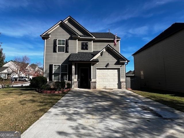 view of front of home with a front yard and a garage