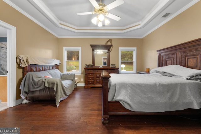 bedroom with dark hardwood / wood-style floors, ceiling fan, a raised ceiling, and ornamental molding