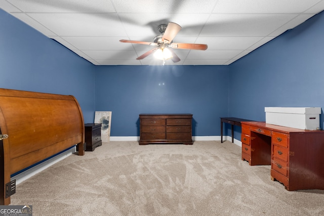 bedroom featuring ceiling fan, a drop ceiling, and light carpet