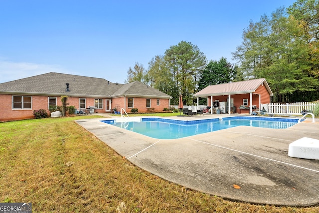 view of swimming pool featuring a patio area and a yard