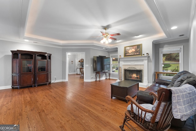 living room featuring wood-type flooring, a wealth of natural light, ornamental molding, and ceiling fan