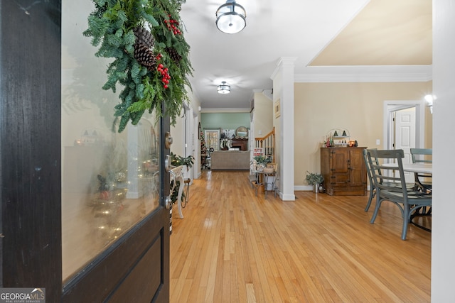 hallway with crown molding and light hardwood / wood-style floors