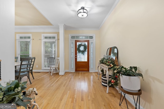 foyer with crown molding and light hardwood / wood-style floors