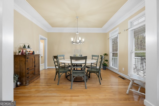 dining area featuring a chandelier, light hardwood / wood-style floors, and ornamental molding