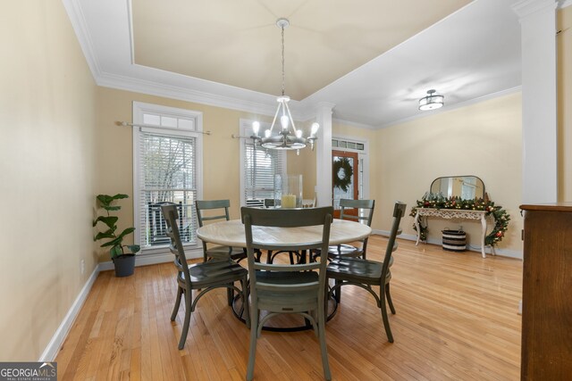 dining area featuring hardwood / wood-style floors, a notable chandelier, and crown molding