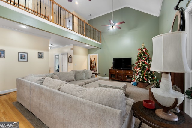 living room featuring ceiling fan, crown molding, high vaulted ceiling, and light hardwood / wood-style flooring