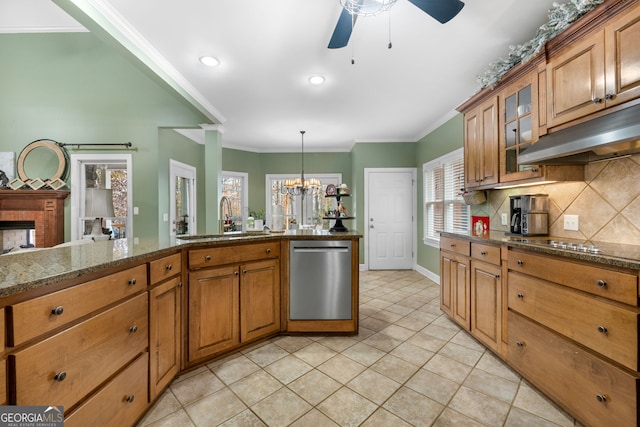 kitchen with a fireplace, dark stone counters, ceiling fan with notable chandelier, sink, and dishwasher