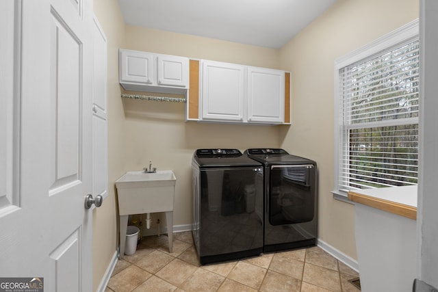 washroom featuring washer and clothes dryer, light tile patterned flooring, and cabinets