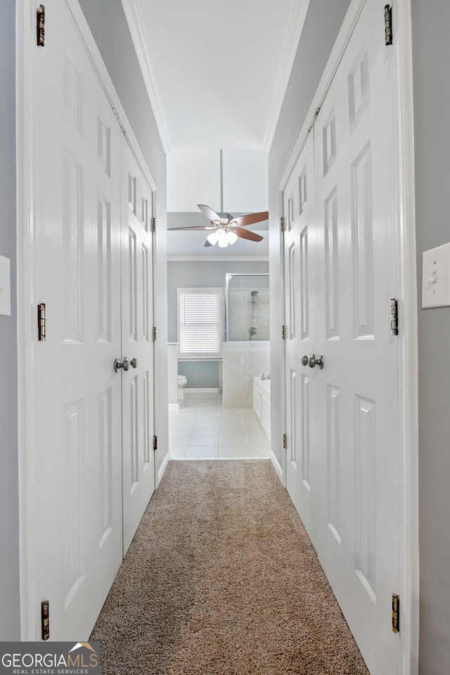 hall featuring light colored carpet and ornamental molding