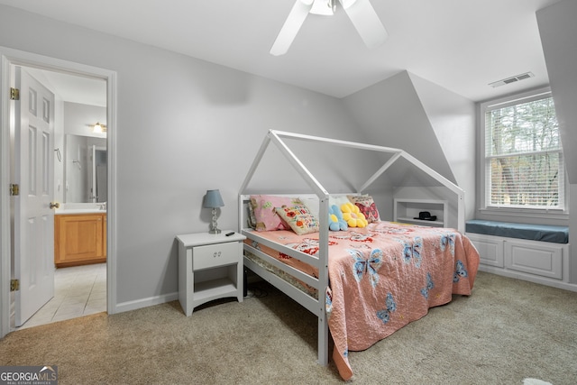 bedroom with light colored carpet, ensuite bath, and ceiling fan