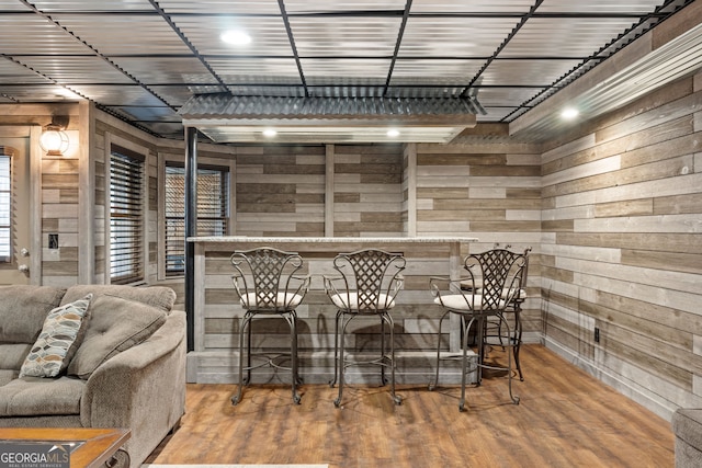 bar featuring hardwood / wood-style floors and wood walls