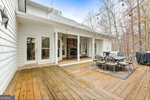 wooden deck featuring grilling area and an outdoor fireplace