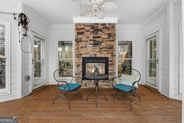 sunroom / solarium with ceiling fan, a fireplace, and a healthy amount of sunlight