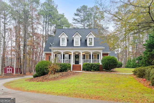 cape cod house with a front lawn and covered porch