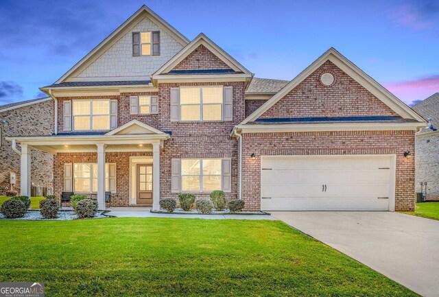 craftsman-style house featuring a yard and a garage