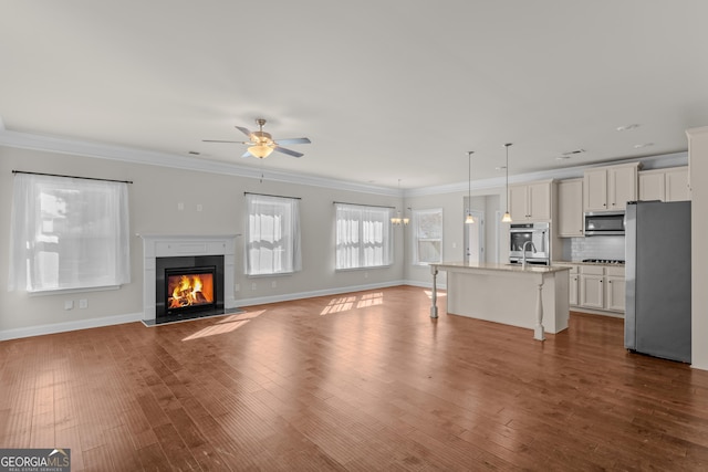 unfurnished living room featuring sink, ornamental molding, dark hardwood / wood-style floors, and ceiling fan