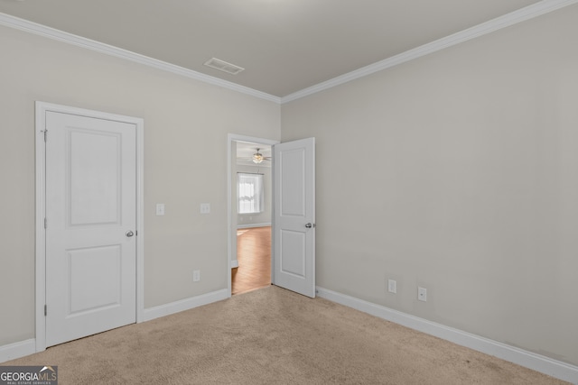 unfurnished bedroom featuring crown molding and light colored carpet