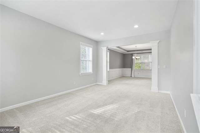 carpeted empty room with a chandelier