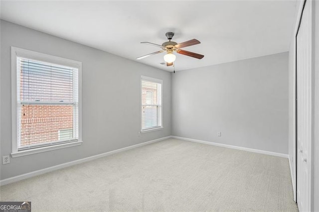 spare room with light colored carpet and ceiling fan