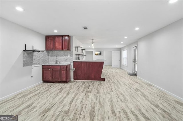 kitchen with light wood-type flooring, tasteful backsplash, and sink