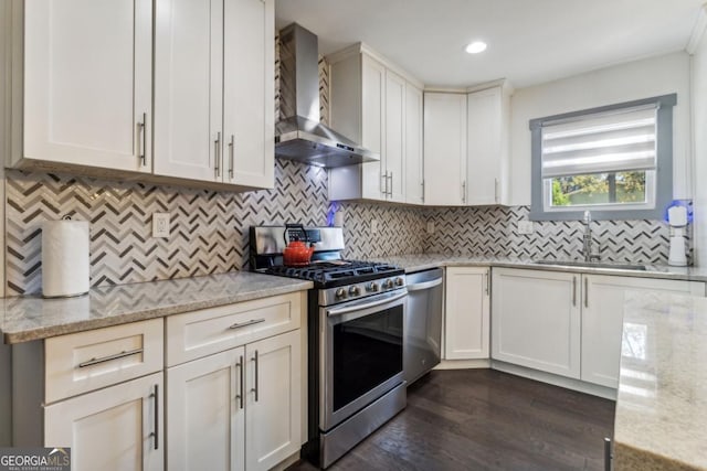 kitchen featuring light stone countertops, dark hardwood / wood-style flooring, stainless steel appliances, and wall chimney range hood