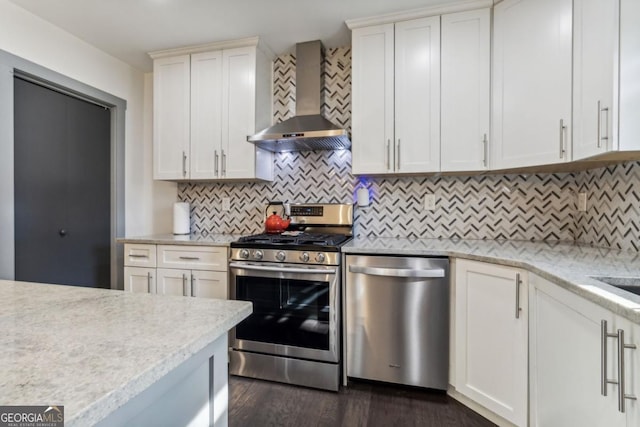 kitchen featuring white cabinets, wall chimney exhaust hood, dark hardwood / wood-style floors, and stainless steel appliances