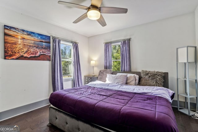 bedroom featuring multiple windows, ceiling fan, and dark hardwood / wood-style flooring