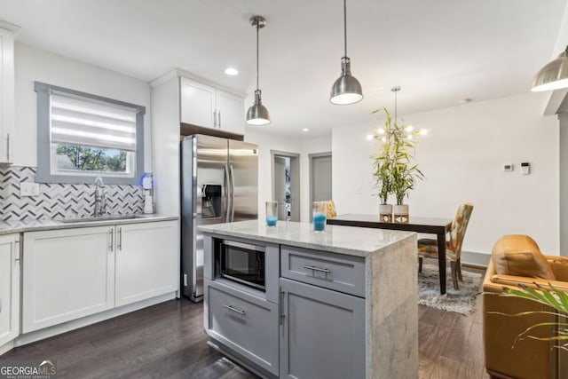 kitchen featuring decorative light fixtures, white cabinetry, backsplash, and dark wood-type flooring