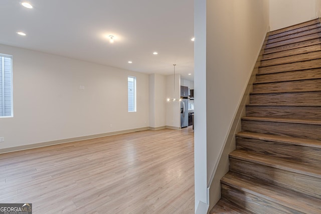 stairway with a notable chandelier and hardwood / wood-style flooring