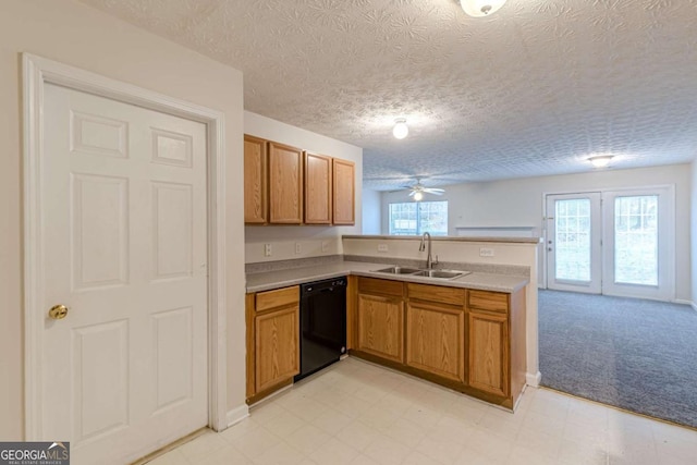 kitchen featuring a textured ceiling, plenty of natural light, black dishwasher, and sink