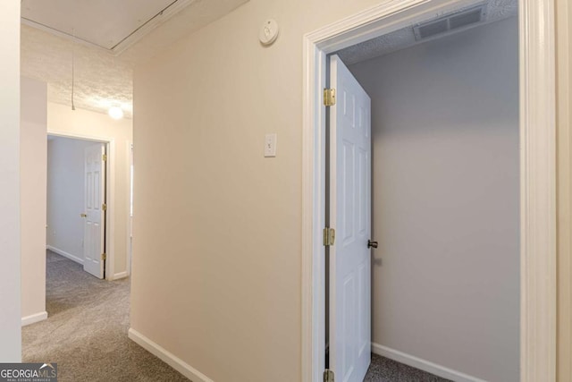 corridor with carpet and a textured ceiling