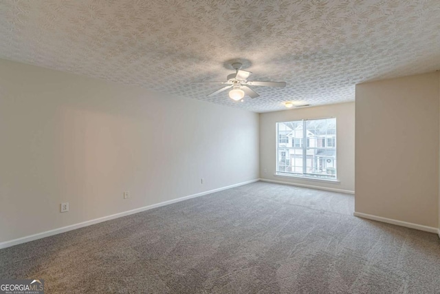 carpeted spare room featuring ceiling fan and a textured ceiling