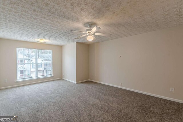 carpeted empty room featuring ceiling fan and a textured ceiling