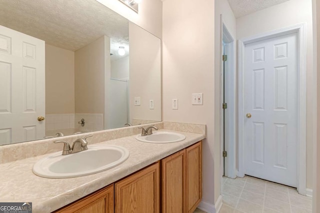 bathroom featuring a washtub, vanity, and a textured ceiling