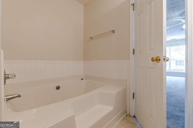 bathroom with a tub to relax in, tile patterned floors, and a textured ceiling