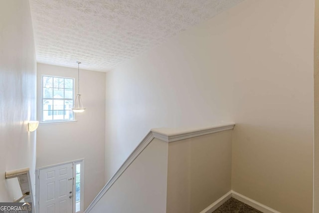 stairs featuring a textured ceiling